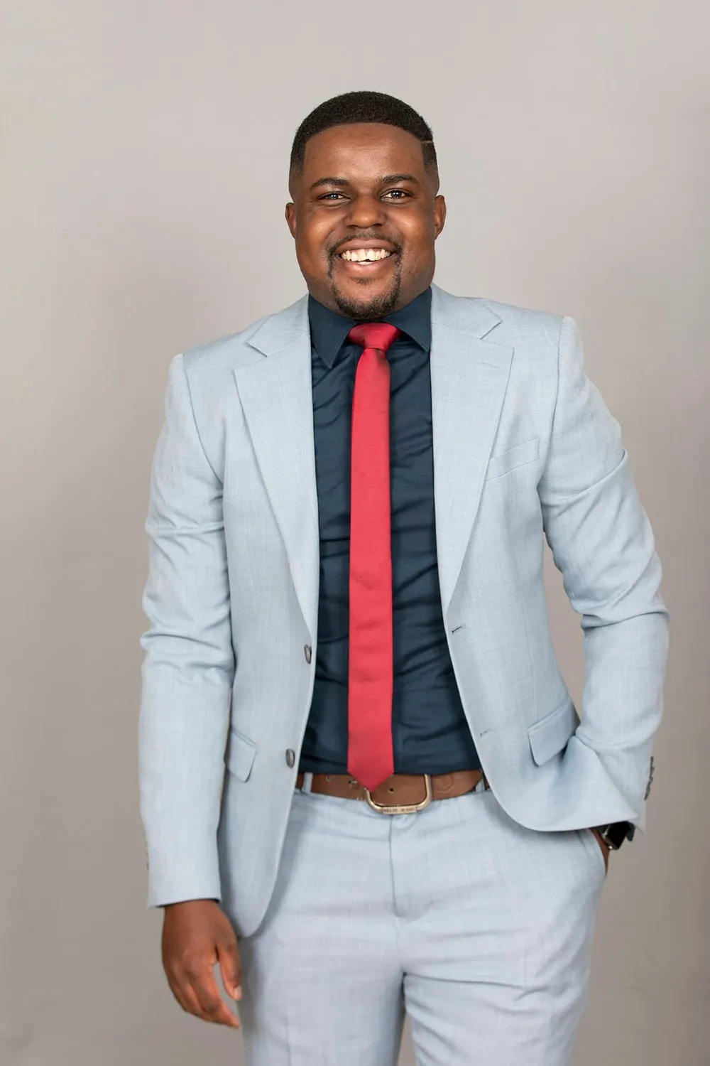 Andrew Tsuro in a light blue suit and red tie