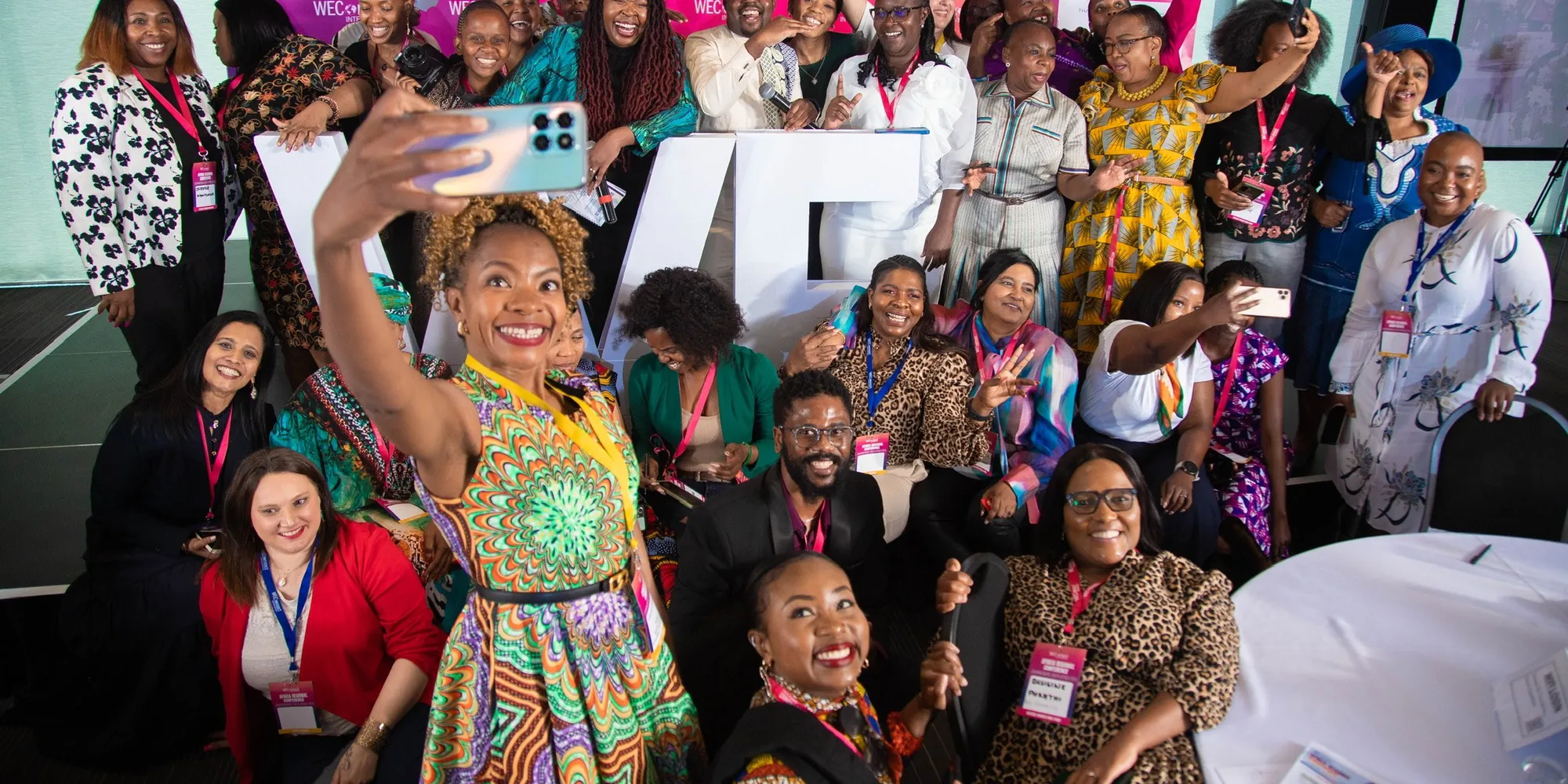 A conference audience cheering for a group photograph