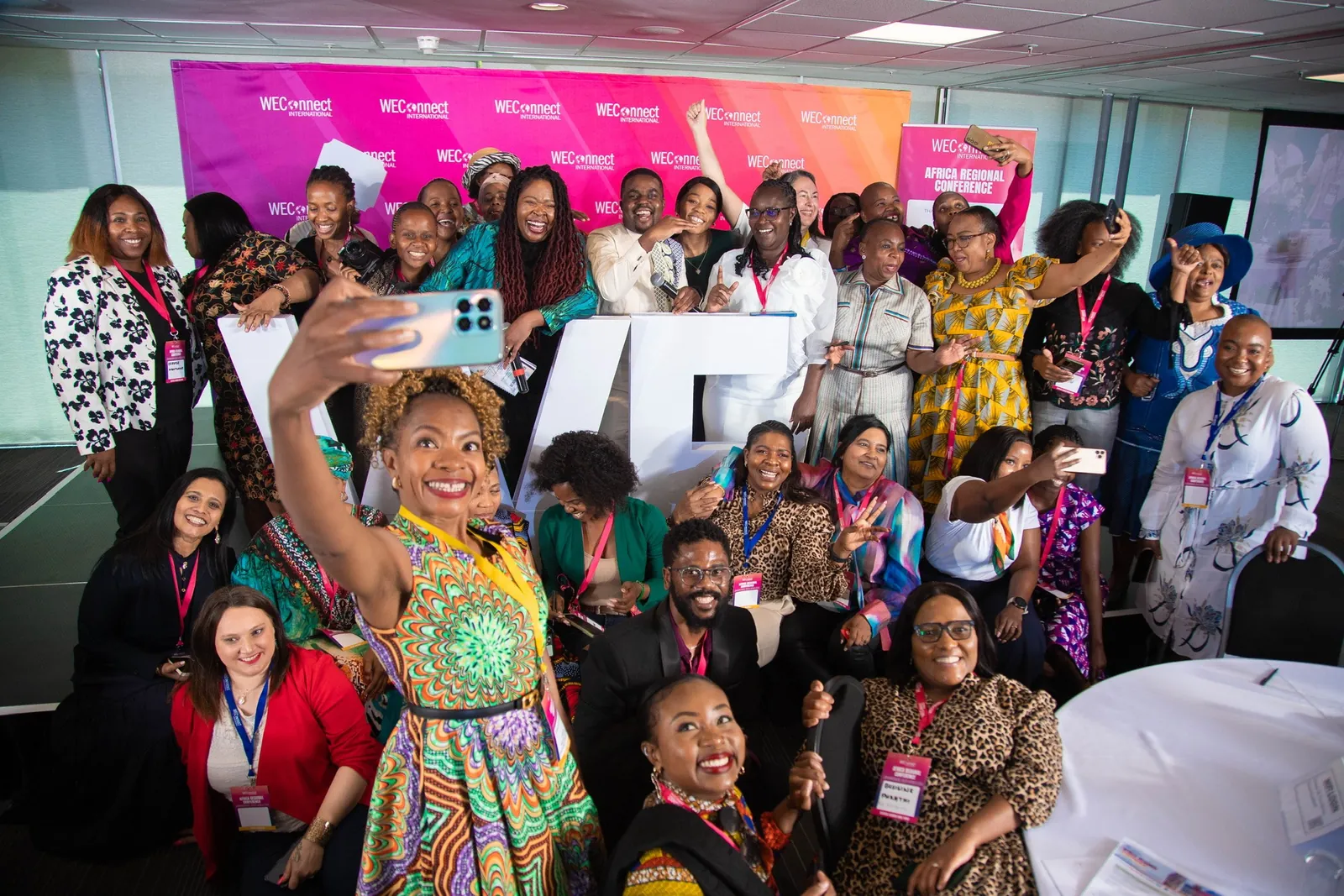 A conference audience cheering for a group photograph