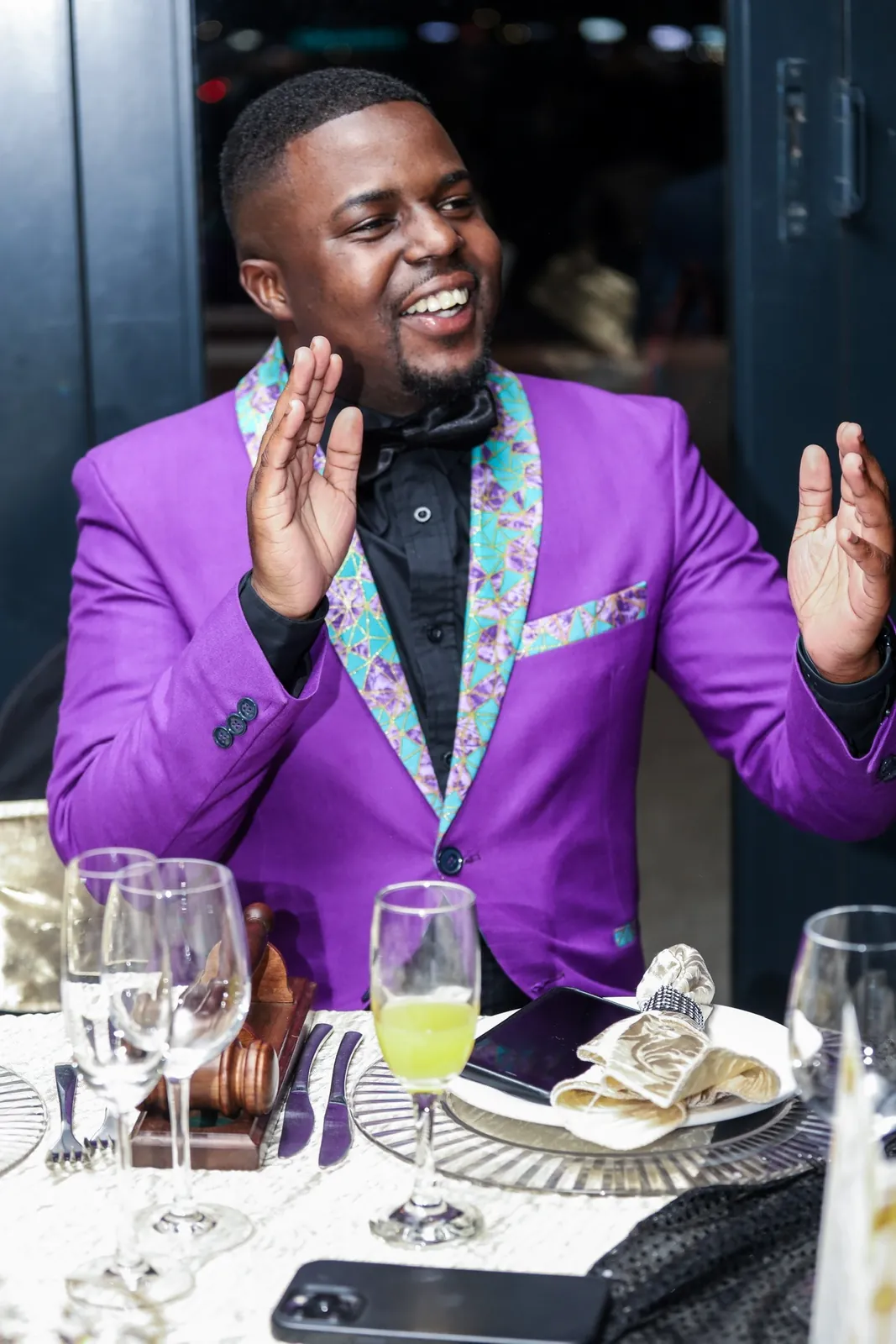 Andrew in a purple dinner jacket, laughing at a table