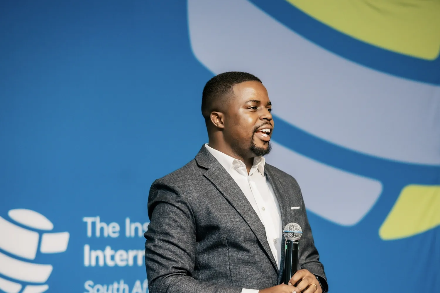 Andrew speaking with a handheld microphone