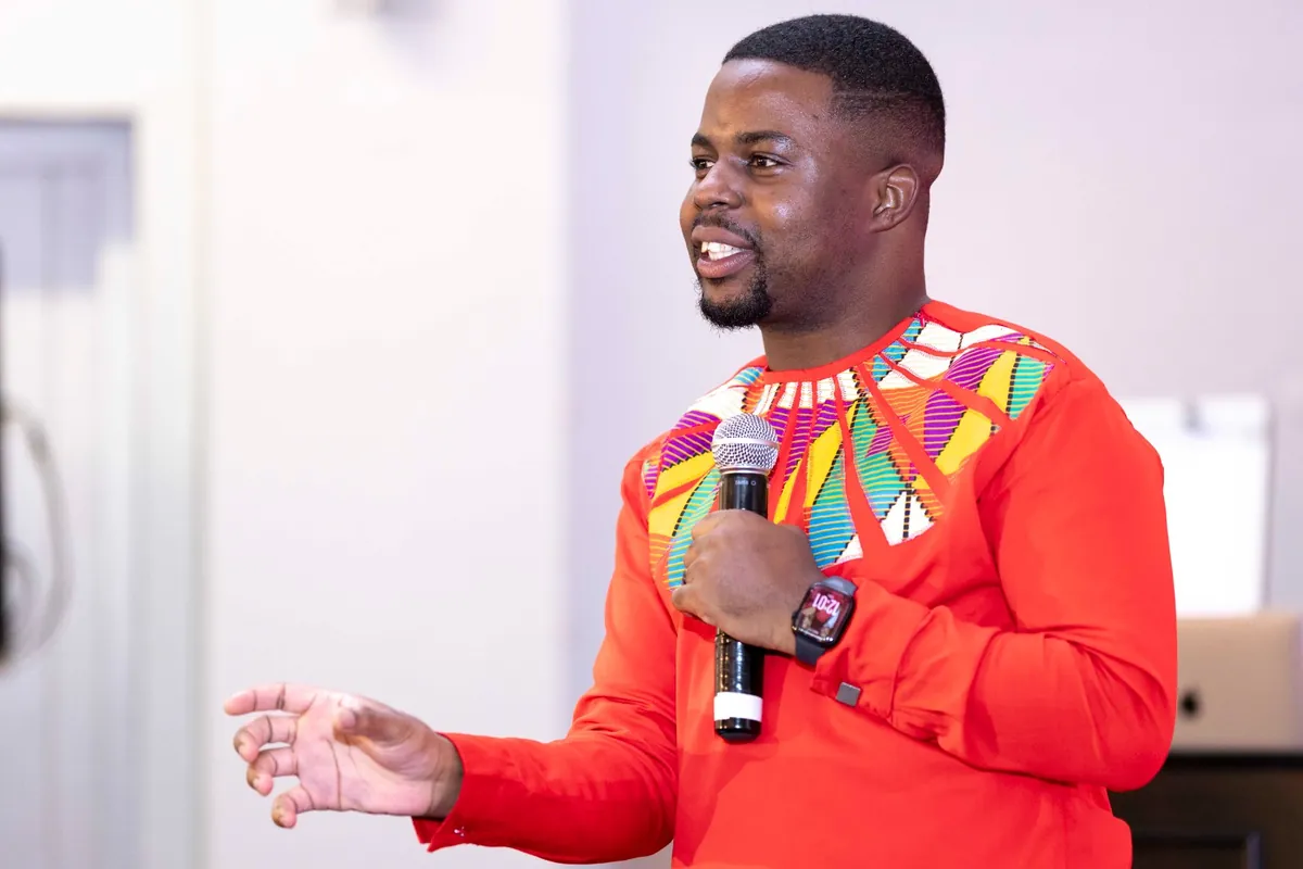 Andrew Tsuro speaking in African-inspired attire