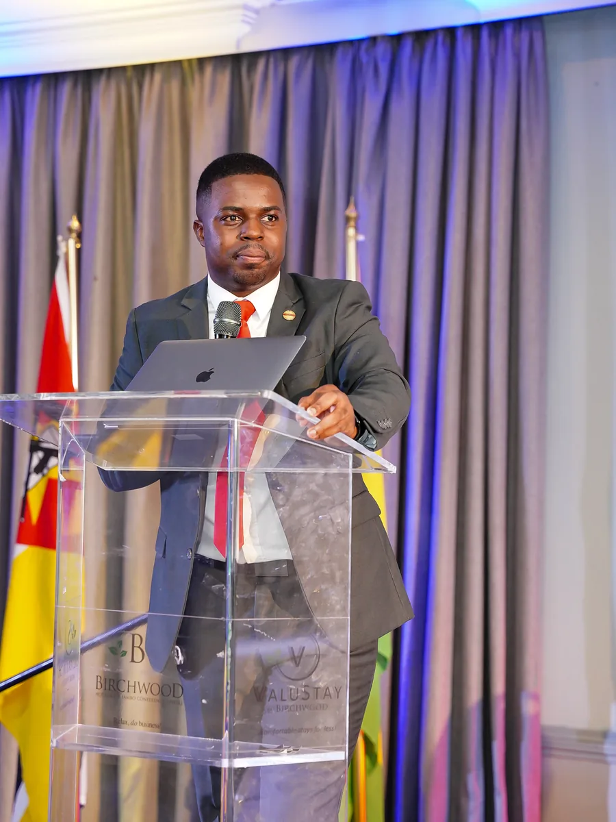 Andrew Tsuro speaking at a podium